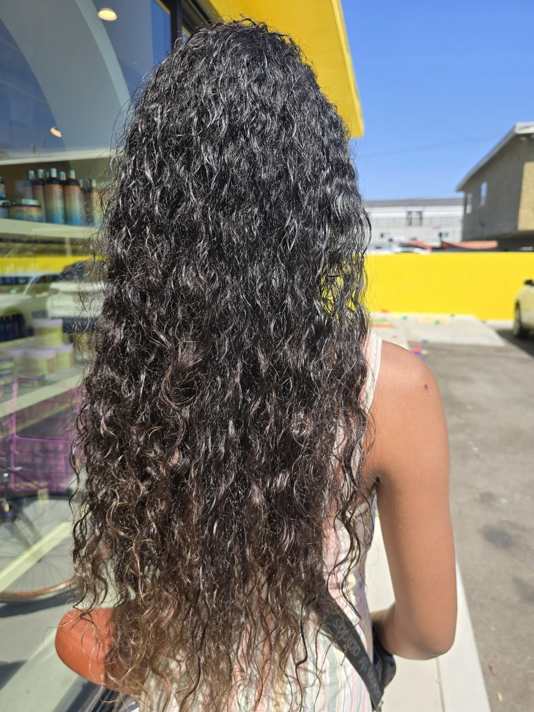 A person with tousled, beachy waves styled using Island Himalayan Salt Texture Spray, embracing a carefree Caribbean vibe.